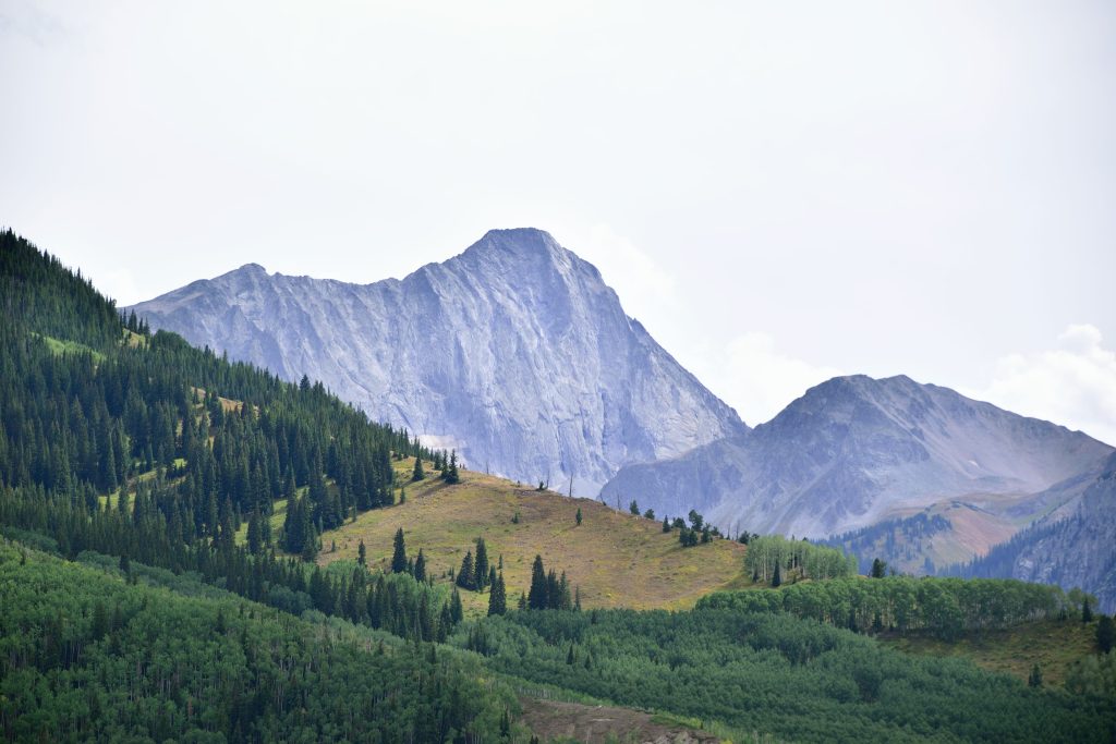 Capitol Peak rising above a forested mountain valley in Colorado