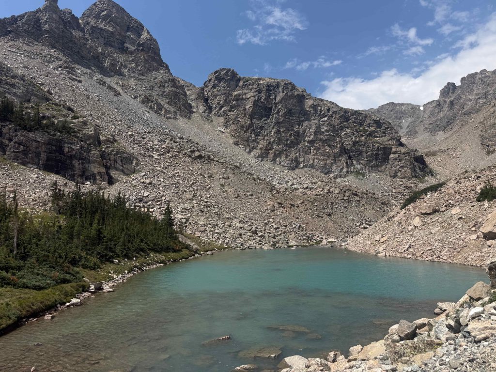 Turquoise waters of an alpine lake surrounded by steep cliffs in Colorado's Indian Peaks Wilderness.