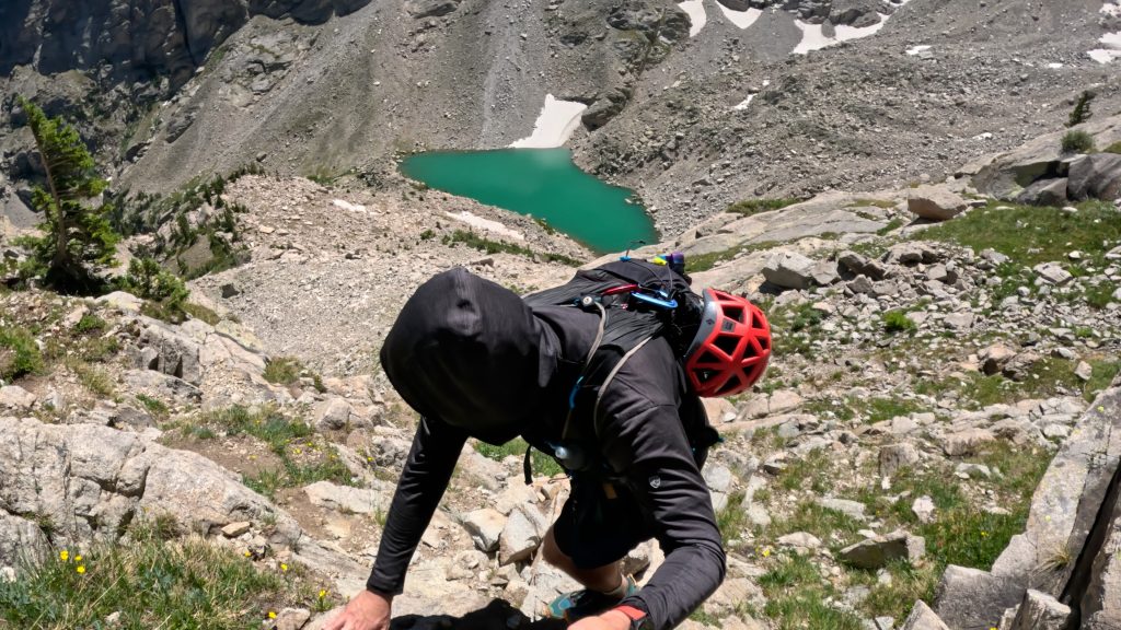 A hiker above triangle lake on the way to Lone Eagle Peak Solo Flight Route. 