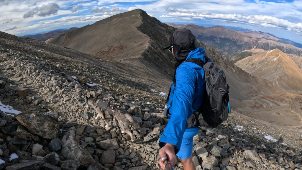 Hiker and dog on a rocky section of the Grays Peak hiking route.