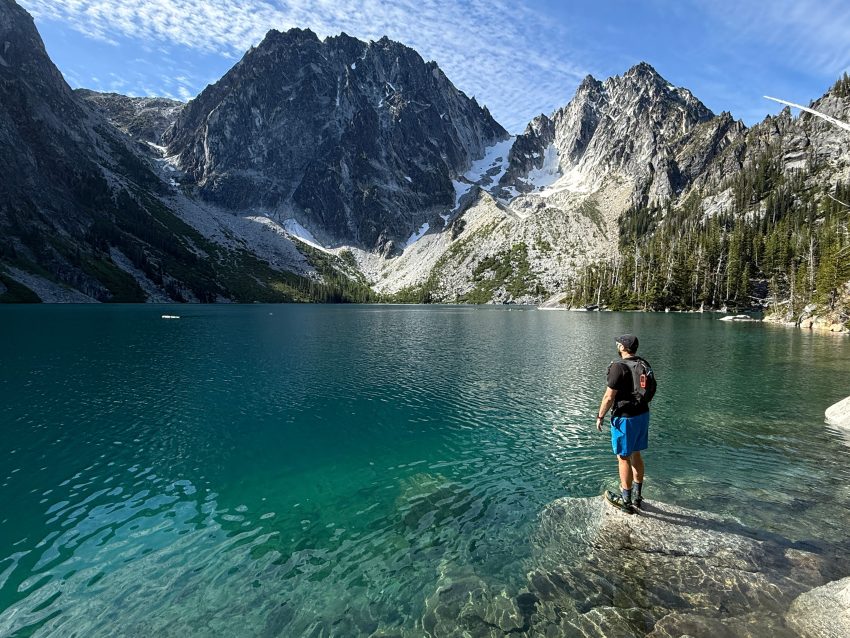 Hiker Standing in front of Colchuck Lake in Washington State.